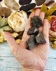 four rough epidote stone pieces in hand