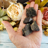 four rough epidote stone pieces in hand