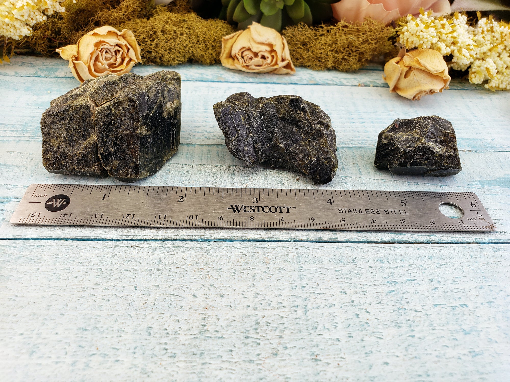 three rough epidote crystal pieces by ruler comparing various sizes from large to small