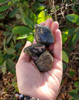 rough epidote pieces in hand