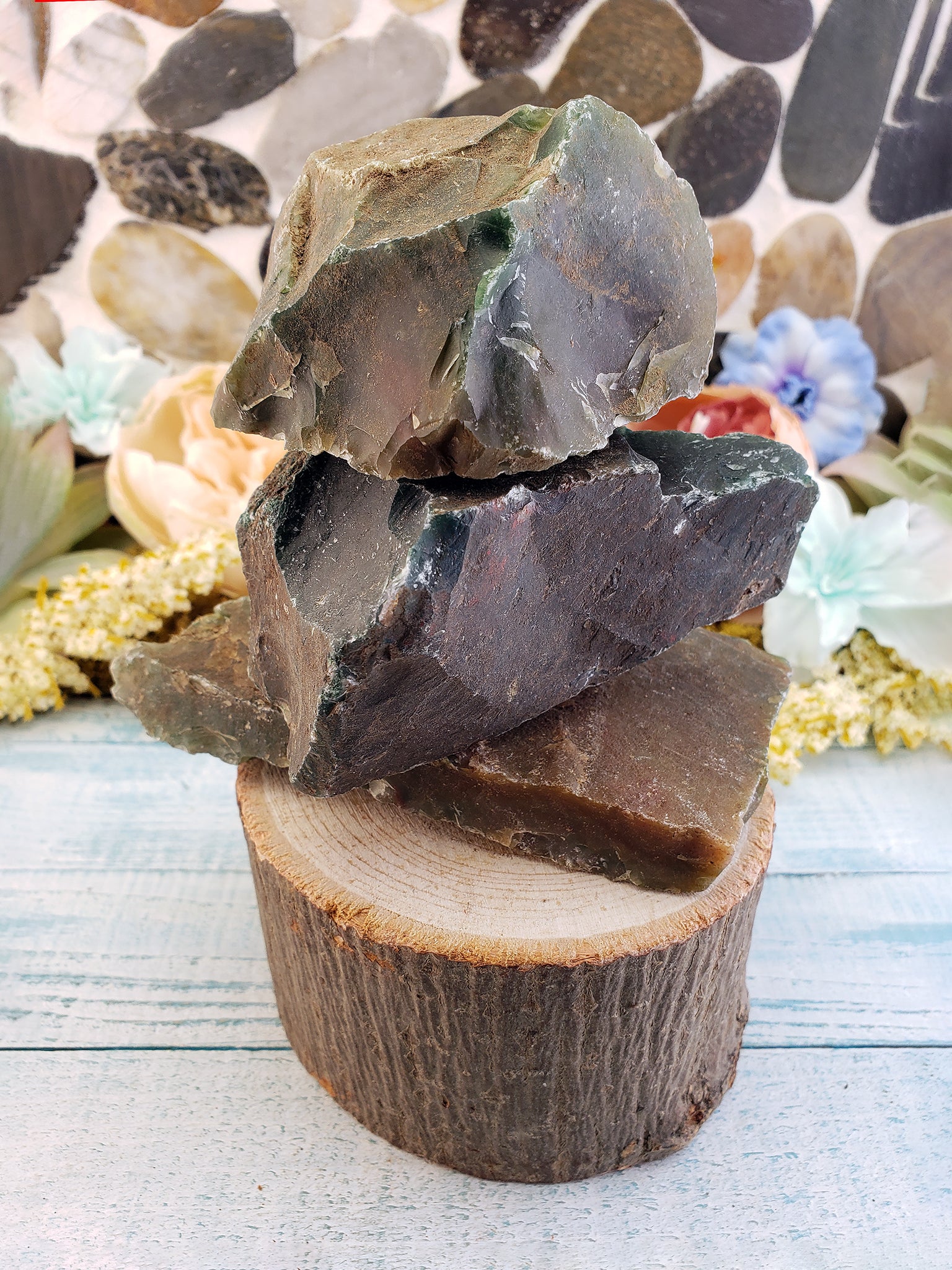 rough fancy jasper stones stacked on prop log