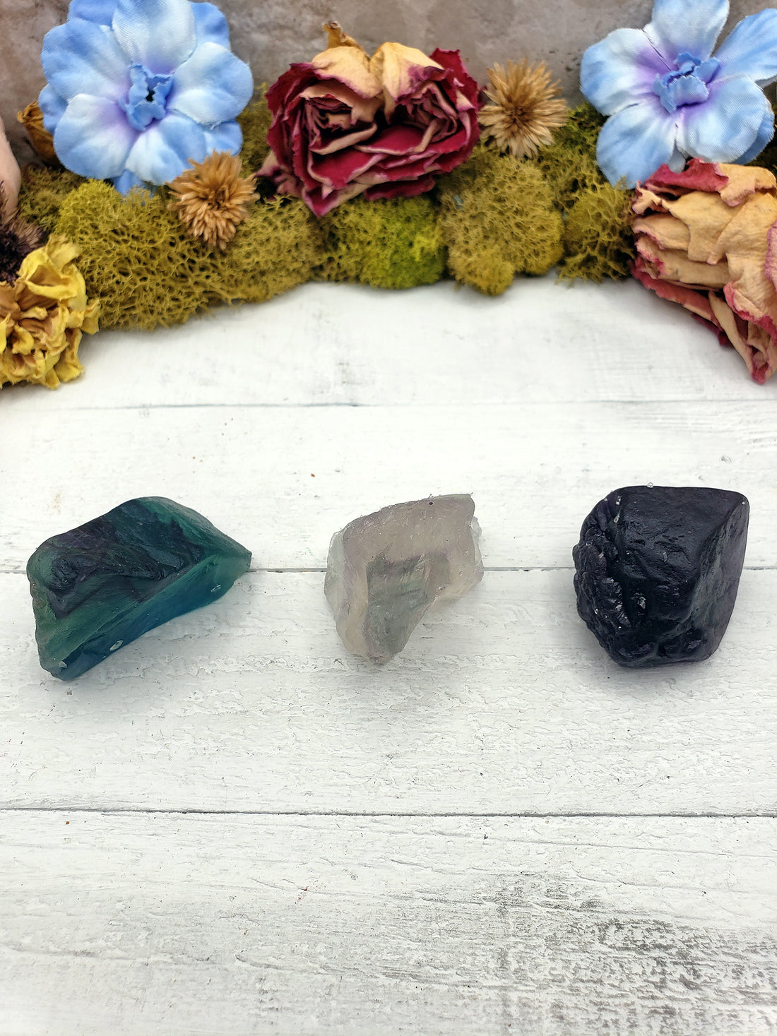 three rough fluorite crystal stones on display