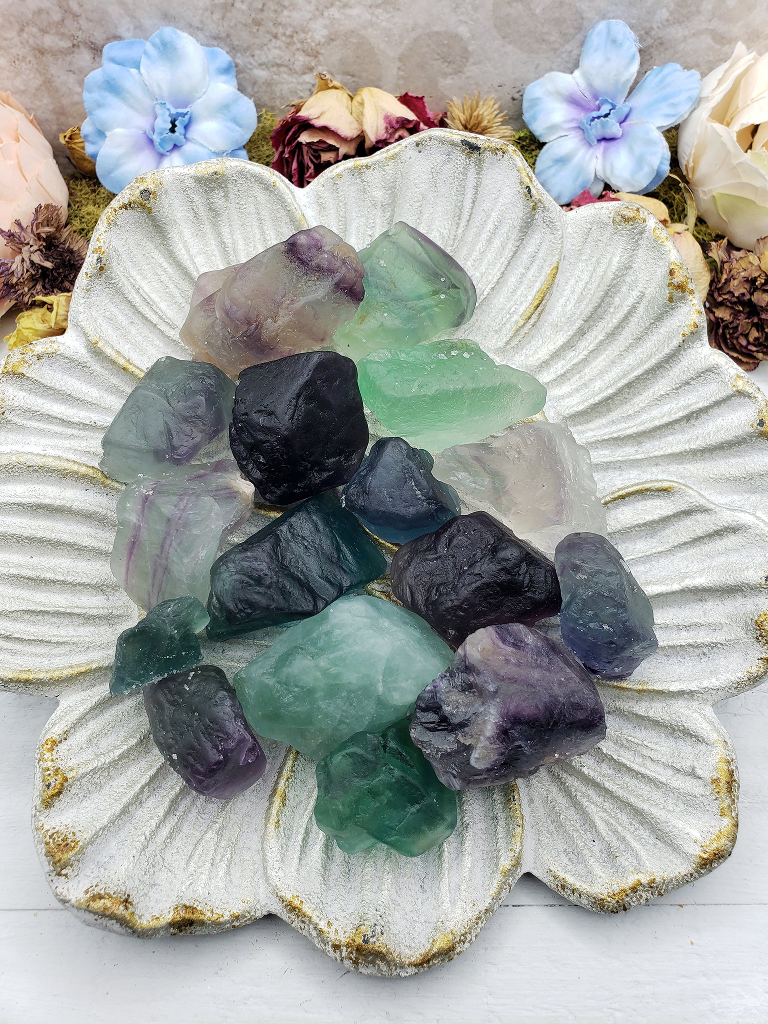 rough fluorite crystal pieces on floral display dish