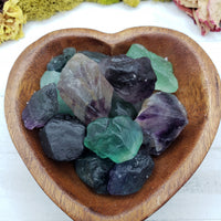 several rough fluorite crystal stones in wooden heart bowl