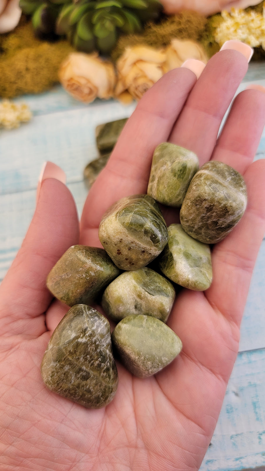 tumbled green snakeskin jasper stones in hand