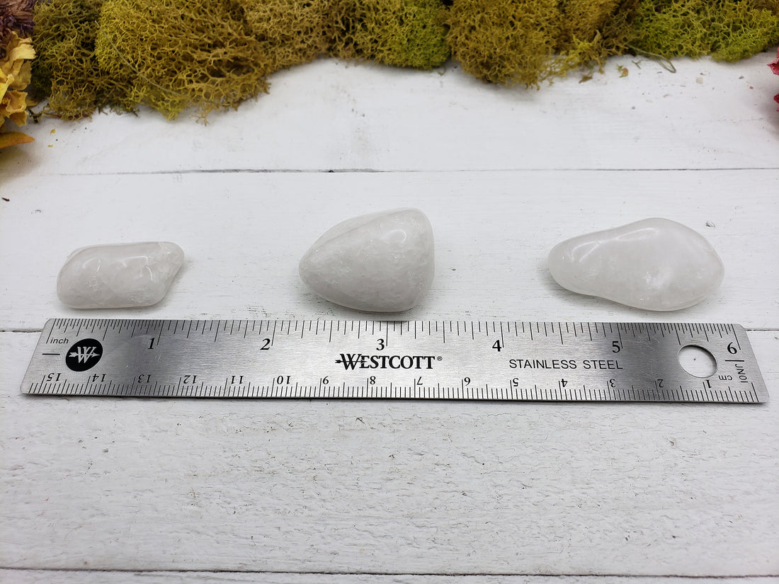 Ruler measuring size of three Milky quartz stones