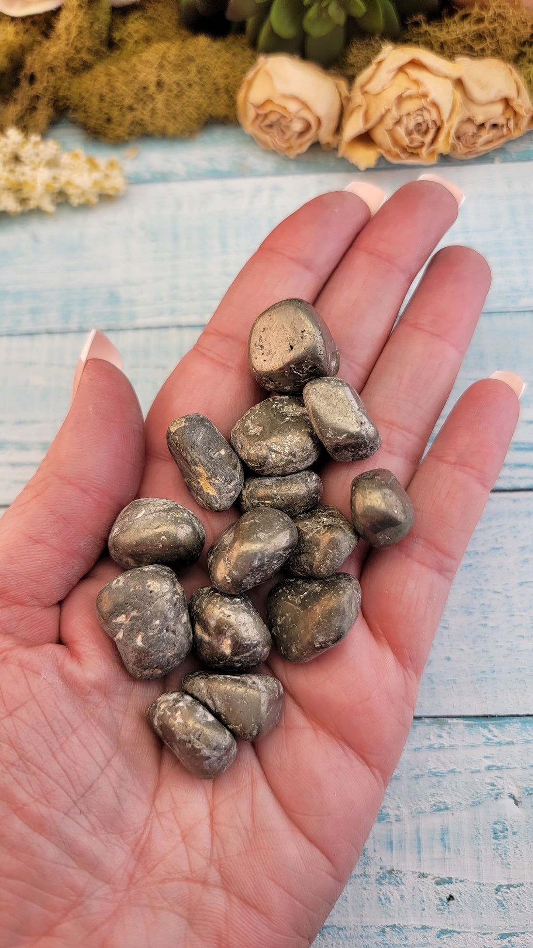 tumbled pyrite stones in hand