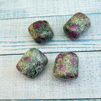 four tumbled ruby kyanite fuchsite stones on display
