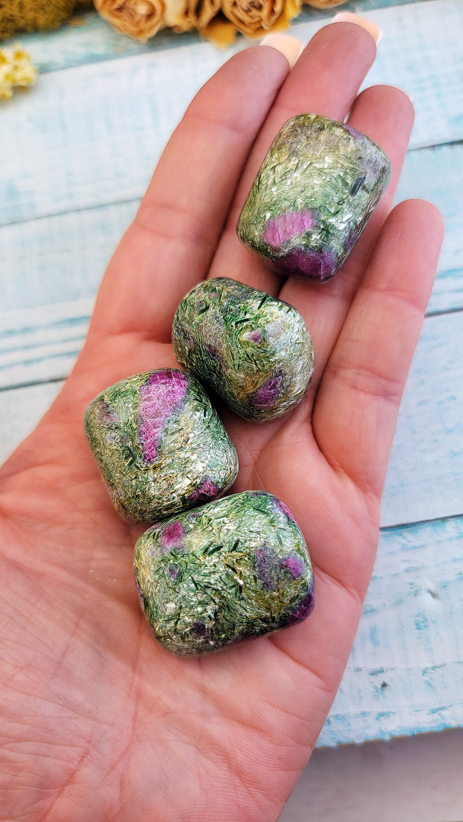 hand holding tumbled ruby kyanite fuchsite crystal pieces