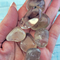 tumbled smoky quartz crystal stones in hand