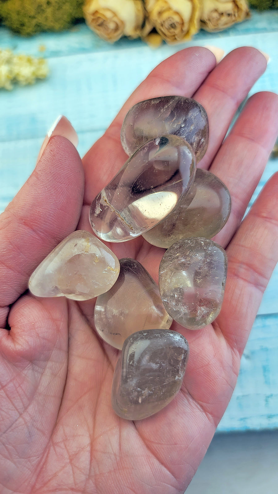 tumbled smoky quartz crystal stones in hand