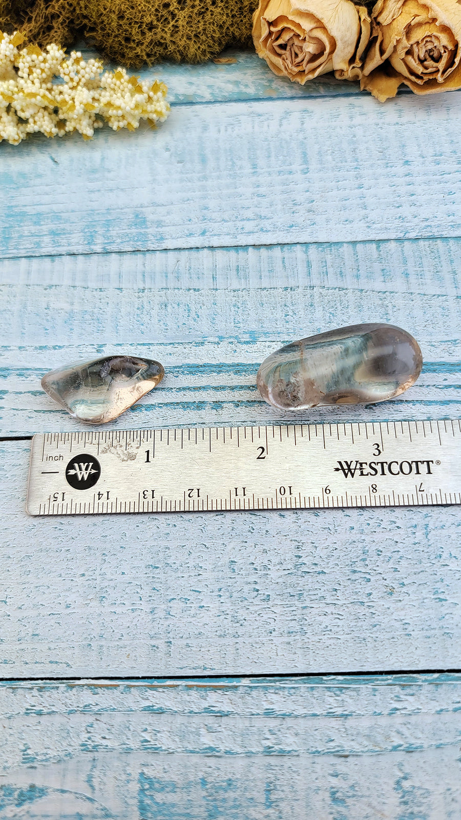 ruler comparing size between two tumbled smoky quartz stones