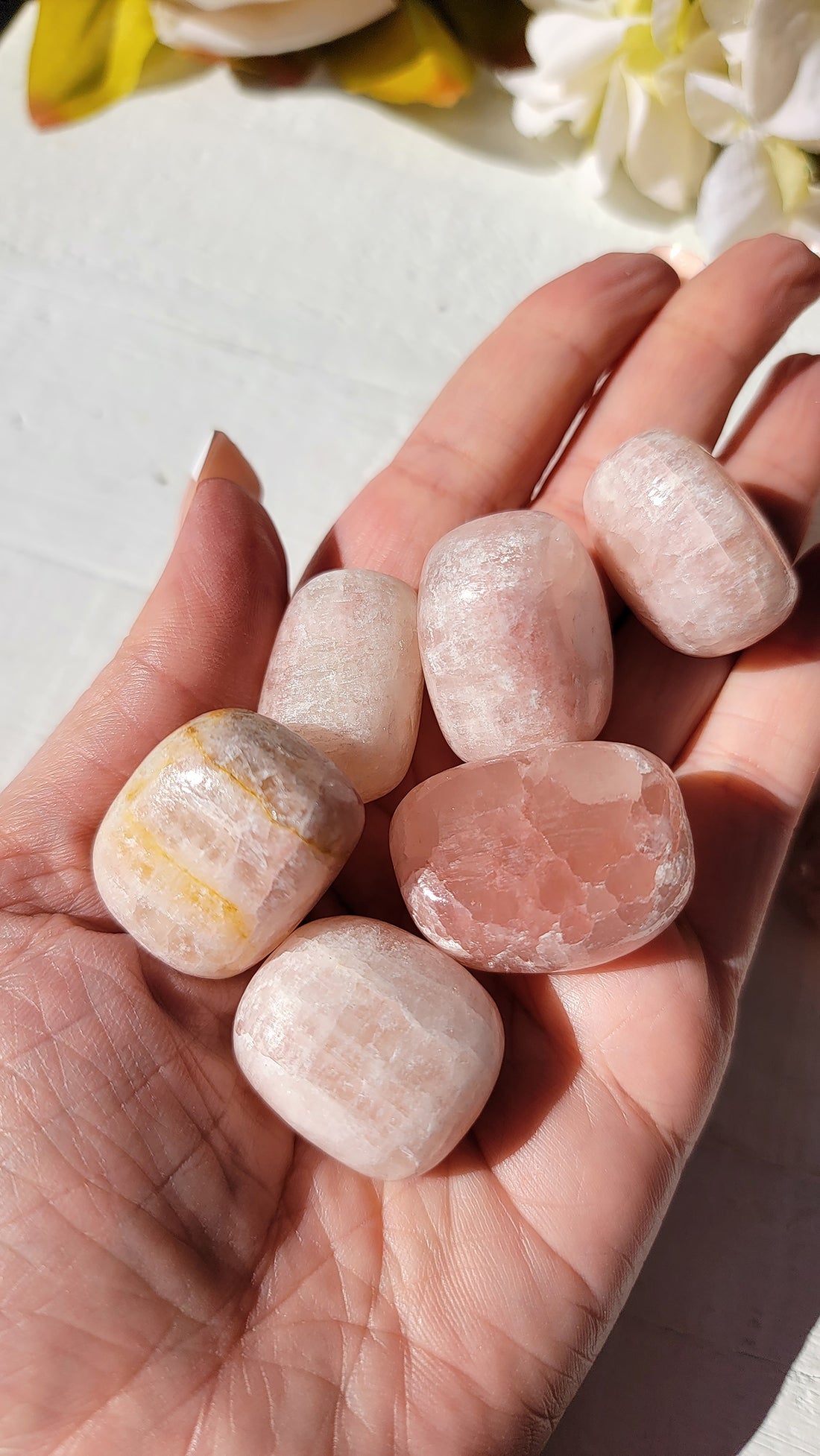 tumbled rose calcite stones in hand