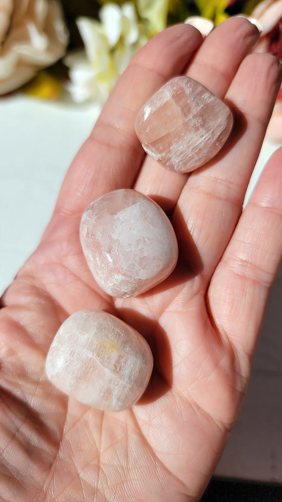 tumbled rose calcite crystals in hand