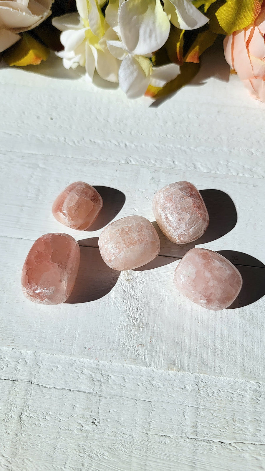five tumbled rose calcite stones on display