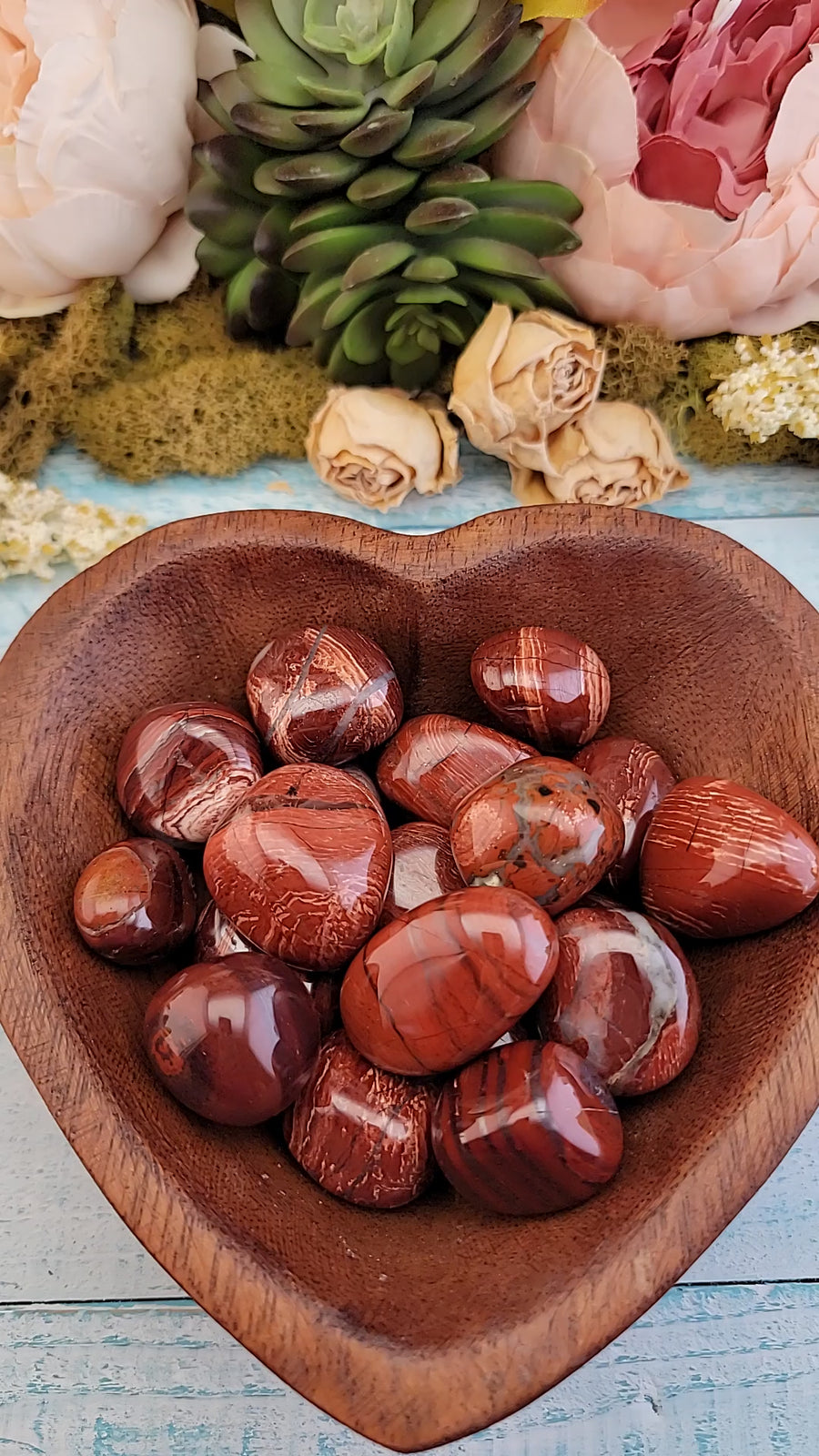 video of tumbled red silver leaf jasper stones in hand, showing off multiple pieces